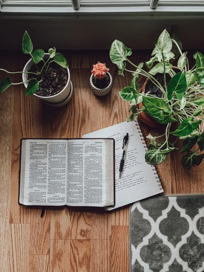 An open Bible on a table beside a cup of coffee